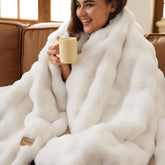 Sofa with soft and fluffy faux fur blankets, soft and fluffy wool blankets and blankets, cream colored bed decorations